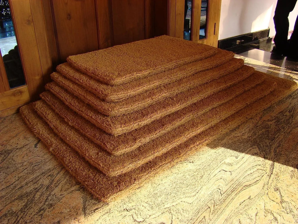 Woven-backed coir mats stacked in a doorway